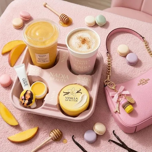 Nadia Beauty products including a smoothie, latte, and skincare items on a pink surface with macarons and a pink handbag.