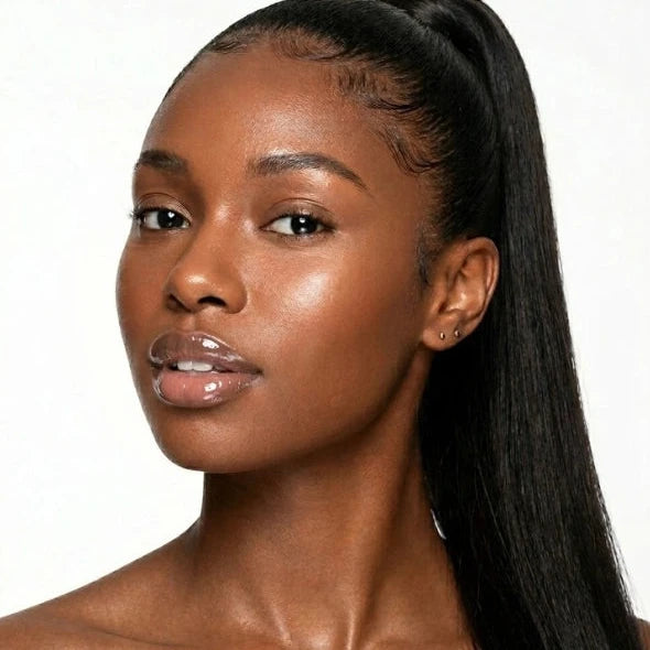 Woman with a high ponytail wearing grape lip balm on a plain background